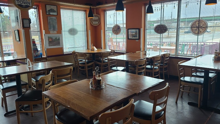 Rustic restaurant dining room with wooden tables chairs and windows