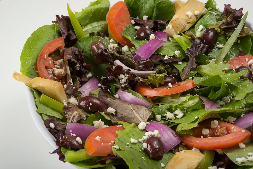 Greek salad with mixed greens, tomatoes, olives, feta, and onions