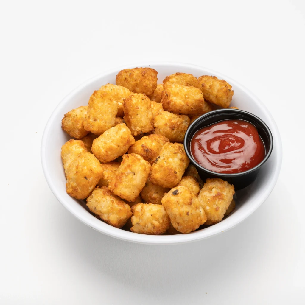 Bowl of crispy potato tots served with ketchup dipping sauce